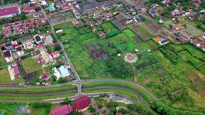 Drone shot of lush green farmlands and buildings in Baiturrahman, Aceh, Indonesia.